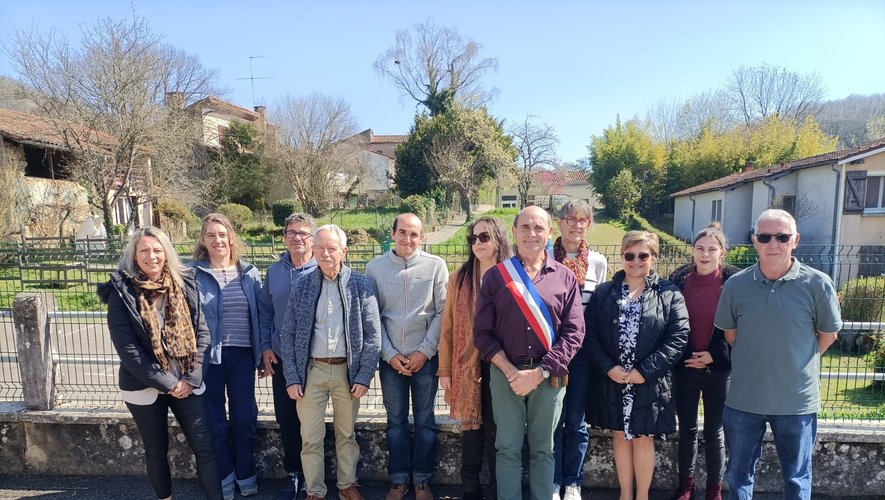 Les membres du conseil municipal de Loubens réunis devant le village, le maire portant son écharpe tricolore.